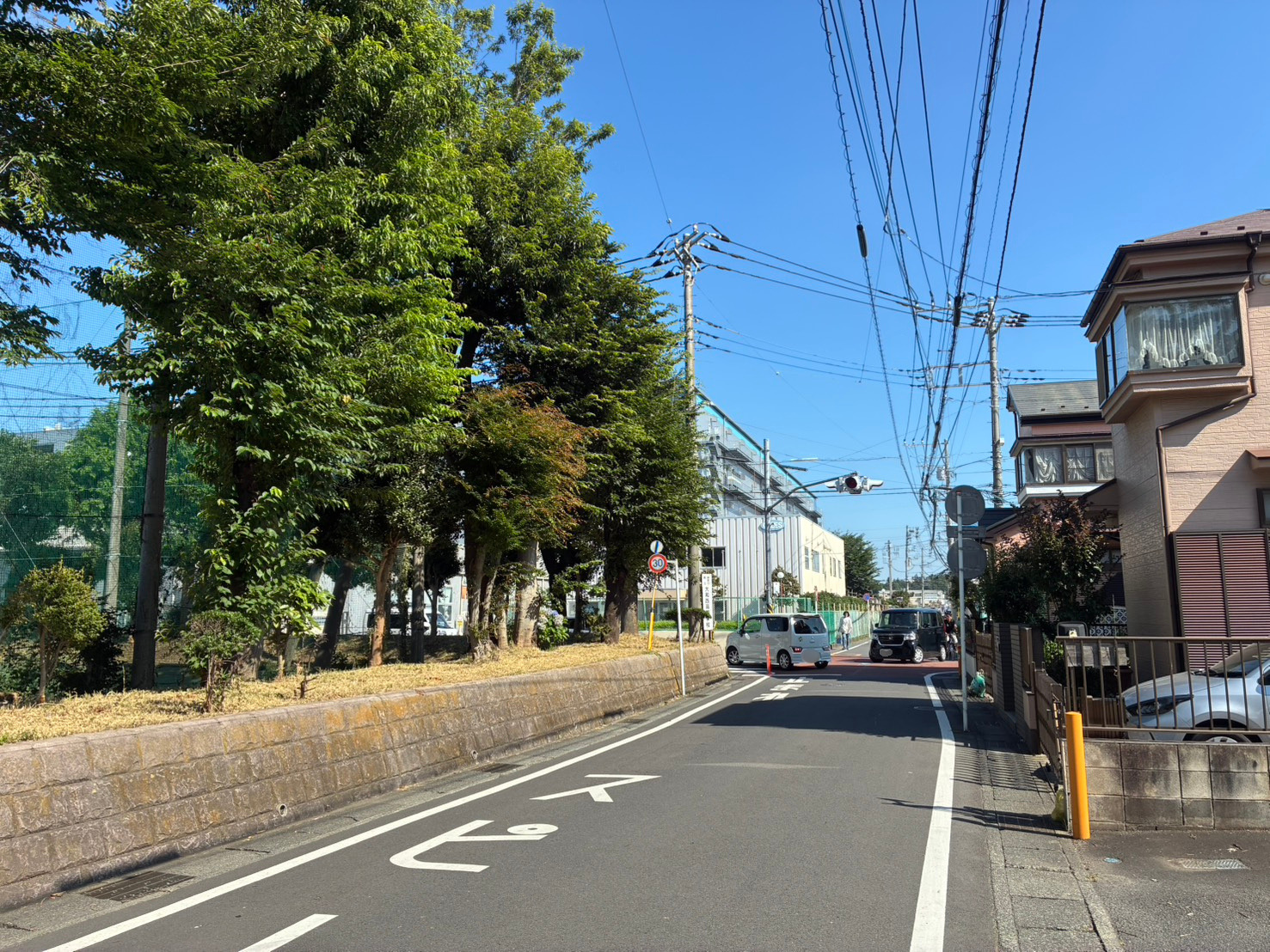 優先側から交差点へ向かう道路。住宅地のなかを直線的に抜けている